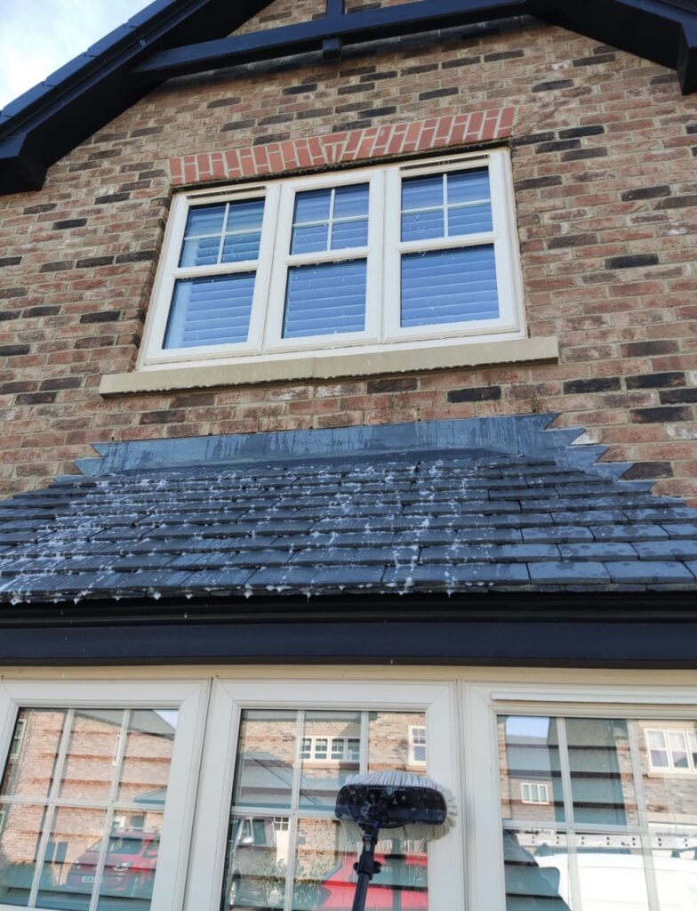 house windows getting cleaned by water fed pole method